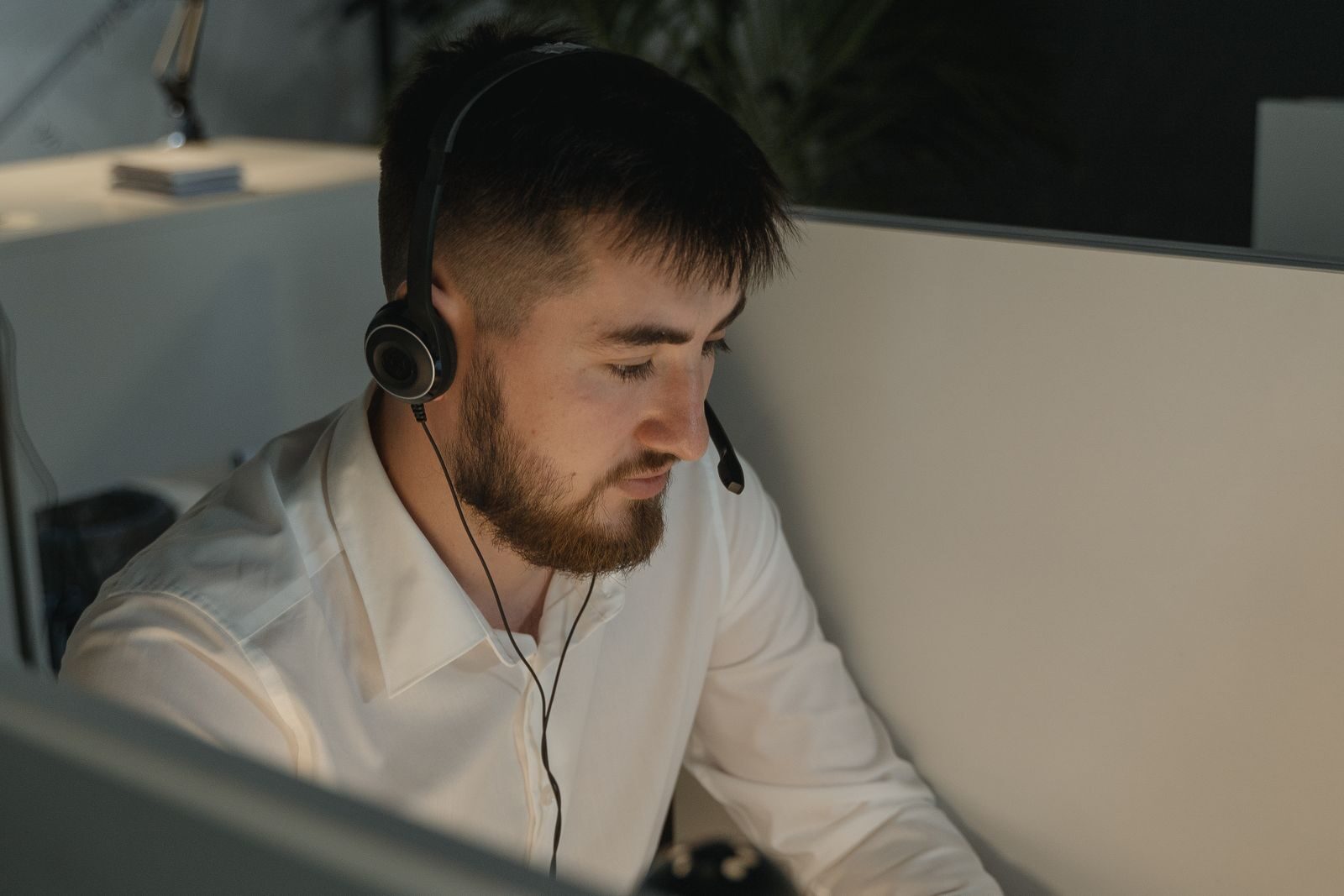 IT support engineer wearing a headset working at a computer